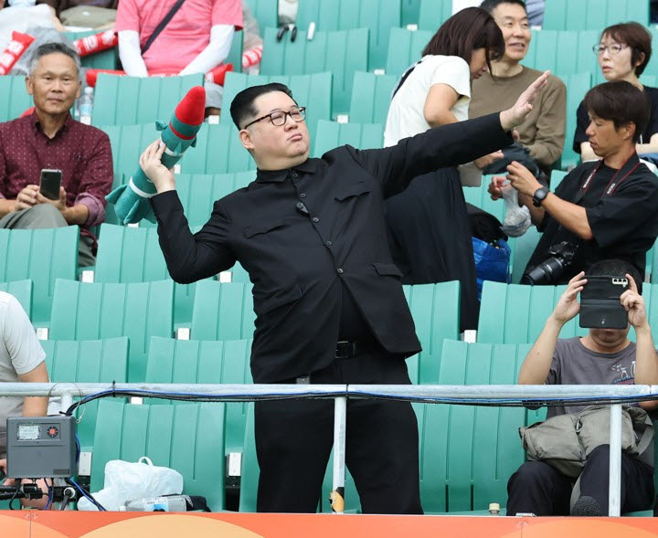 21일 일본 시즈오카현 후쿠로이의 시즈오카 스타디움 에코파에서 열린 2026 아이치·나고야 아시안게임 여자 축구 조별리그 대한민국과 북한의 경기. 관중석에 북한 김정은 국무위원장을 흉내낸 듯한 관람객이 눈길을 끌고 있다. 2026.9.21(사진=연합뉴스)