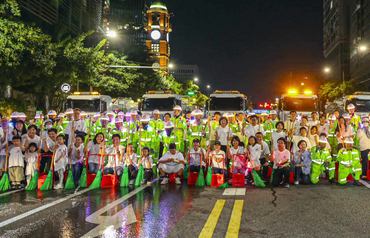 지난 20일 밤, 반포대로에서 서리풀뮤직페스티벌 대미를 장식한 ‘서리풀 청소 퍼레이드’에 참석한 주민 32명과 환경공무관, 서리풀기동대 오토바이, 소형청소차, 살수차가 퍼레이드 후 기념사진을 찍고 있다. (사진=서초구)