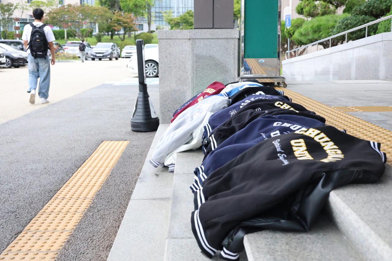 충남대와 공주대의 통합 찬반투표 마지막 날인 10일 대전 충남대 대학본부 앞에 통합에 반대하는 학생들이 두고 간 학과 점퍼(과잠)가 놓여 있다. (사진=연합뉴스)