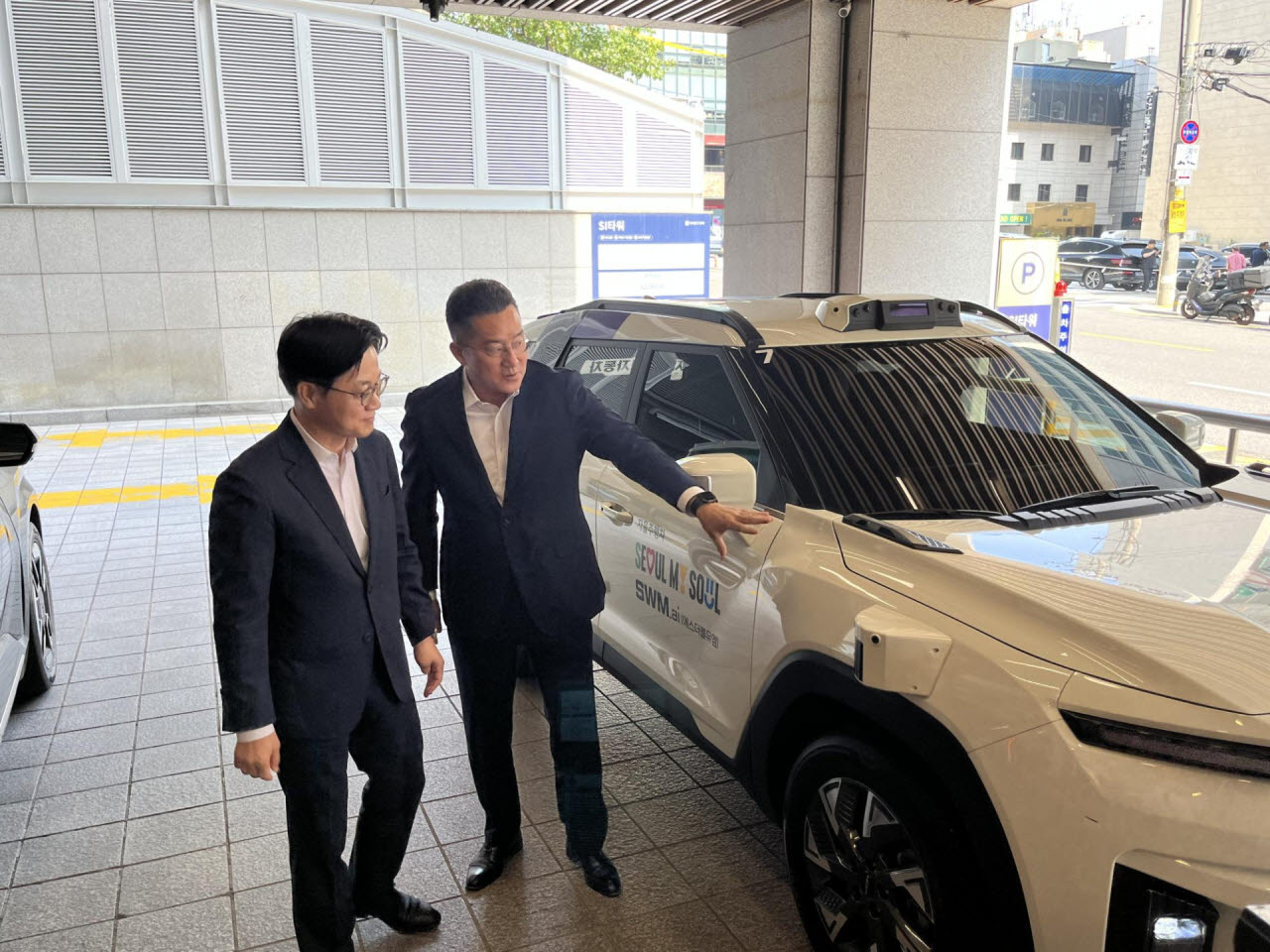 본격적인 강남 도심 로보택시 시승을 앞두고 산업통상부 김정관 장관(왼쪽)에게 SWM.ai의 로보택시 기술을 설명하는 김기혁 대표