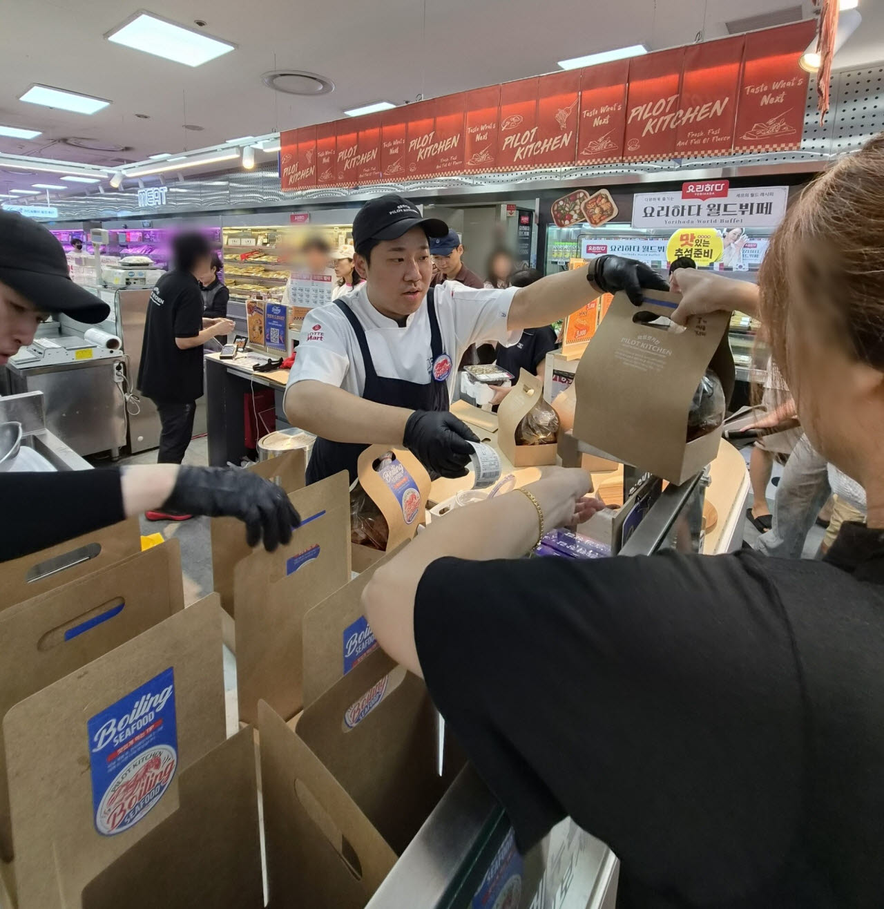 지난 주말 서울 송파구 롯데마트 제타플렉스 잠실점 ‘파일럿 키친’에서 직원이 고객에게 ‘보일링 씨푸드’를 건네고 있다. (사진=한전진 기자)