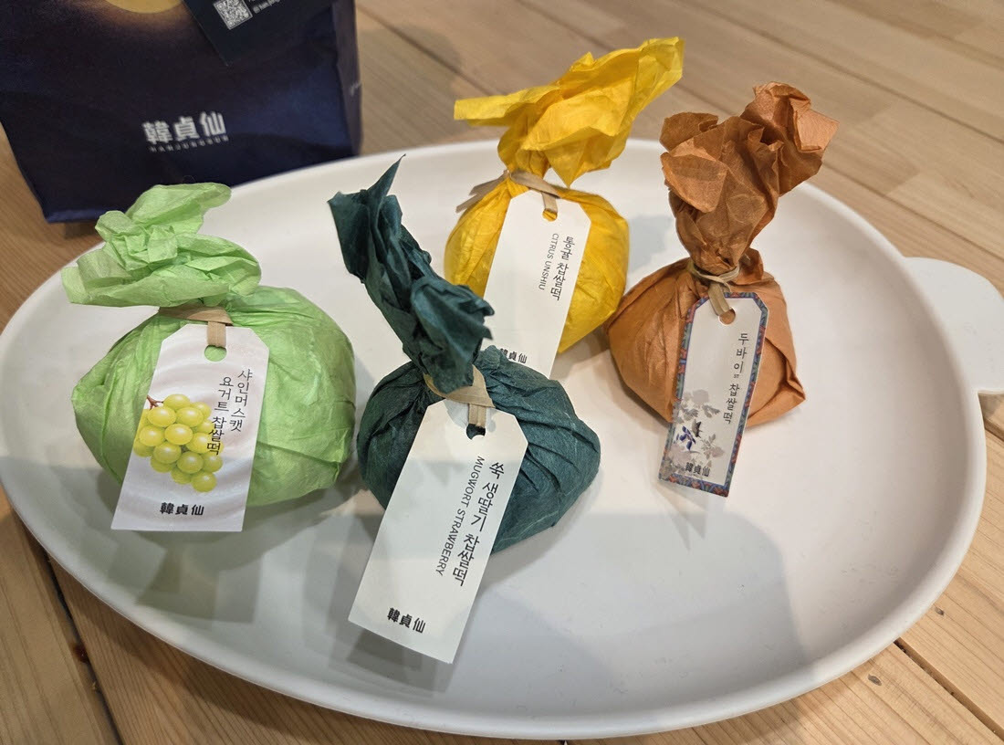 2일 구매한 한정선 찹쌀떡 4종. 왼쪽부터 샤인머스캣 요거트, 앞쪽 쑥 생딸기, 뒤쪽 통귤, 오른쪽 두바이 찹쌀떡이다. 색색의 종이 포장에 제품명 꼬리표를 달았다. (사진=한전진 기자)