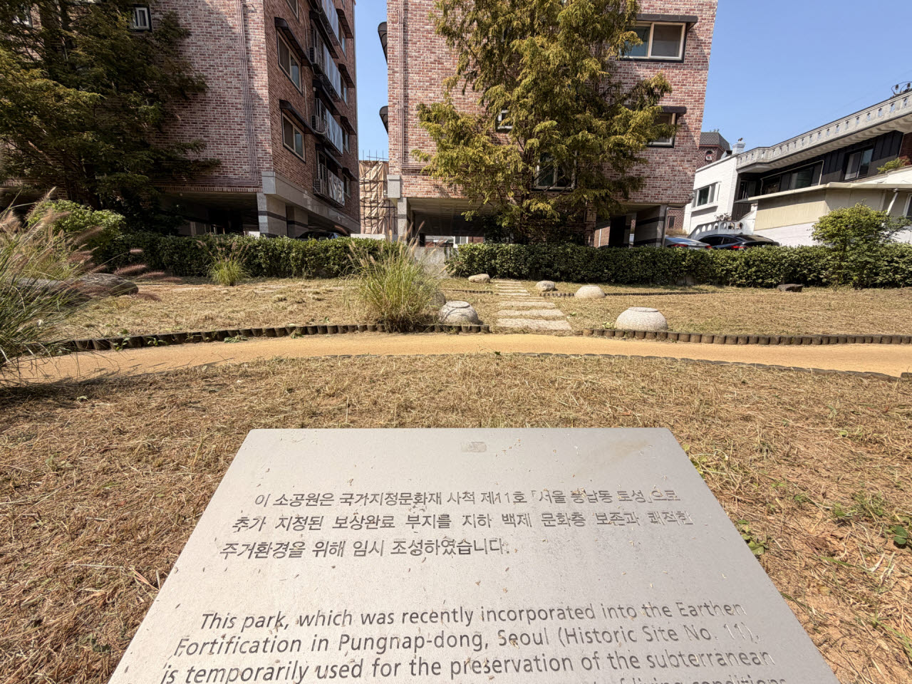 5일 서울 송파구 풍납동의 한 소공원에 '보상완료 부지를 지하 백제 문화층 보존과 쾌적한 주거환경을 위해 임시 조성했다'는 안내문이 적혀 있다. (사진=정윤지 기자)
