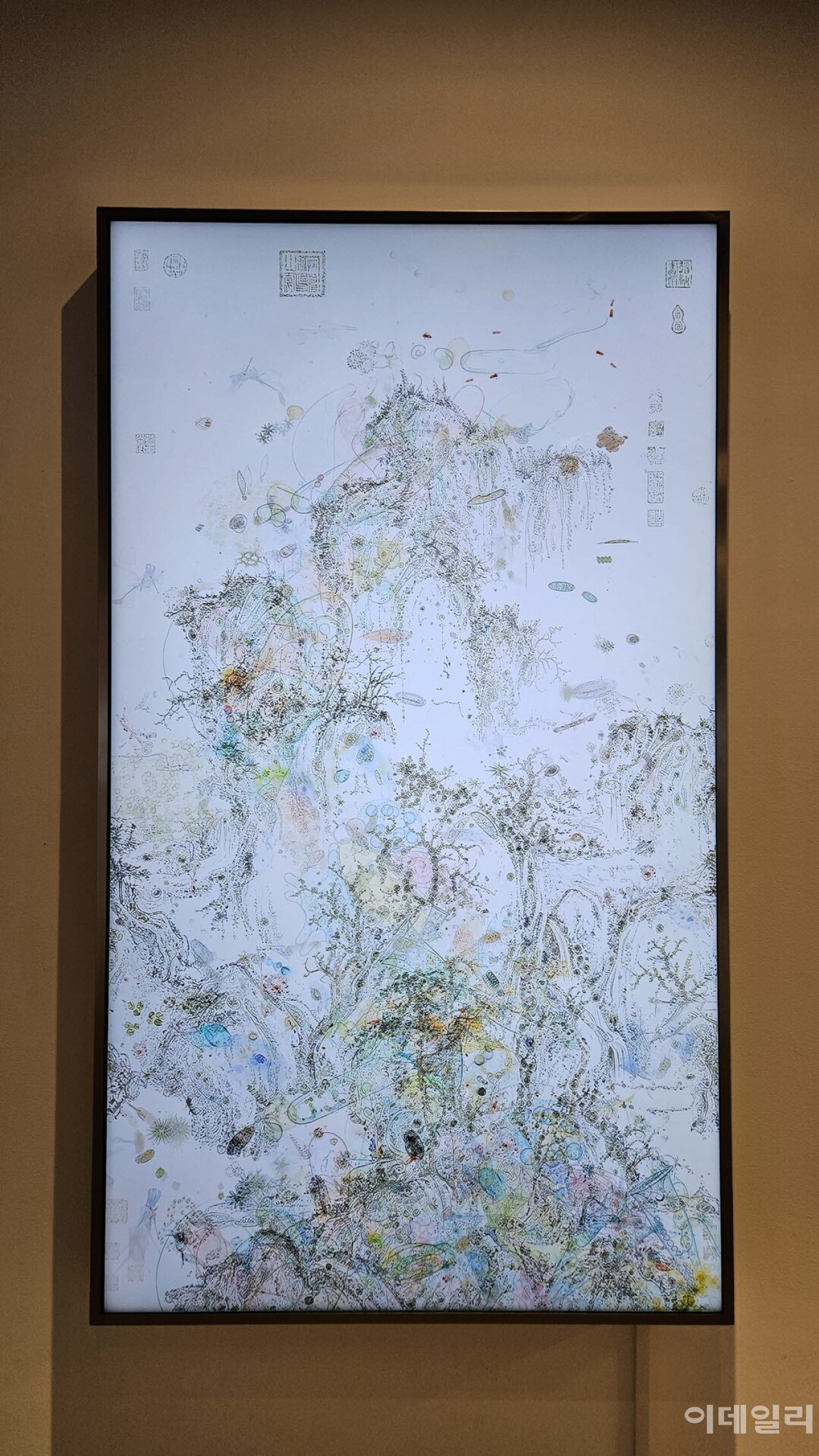 이이남의 ‘미시산수-조춘도 no.2’(2026, 170×97.9㎝). 중국 북송 때 화가 곽희의 ‘조춘도’ 위에 담양 용소폭포에서 건져낸 한 방울 물에서 현미경으로 들여다본 미생물의 세계를 얹어 완성한 미디어 작품이다. 9분 23초짜리 단채널 영상에서 미생물은 쉼없이 꿈틀댄다(사진=오현주 문화전문기자).