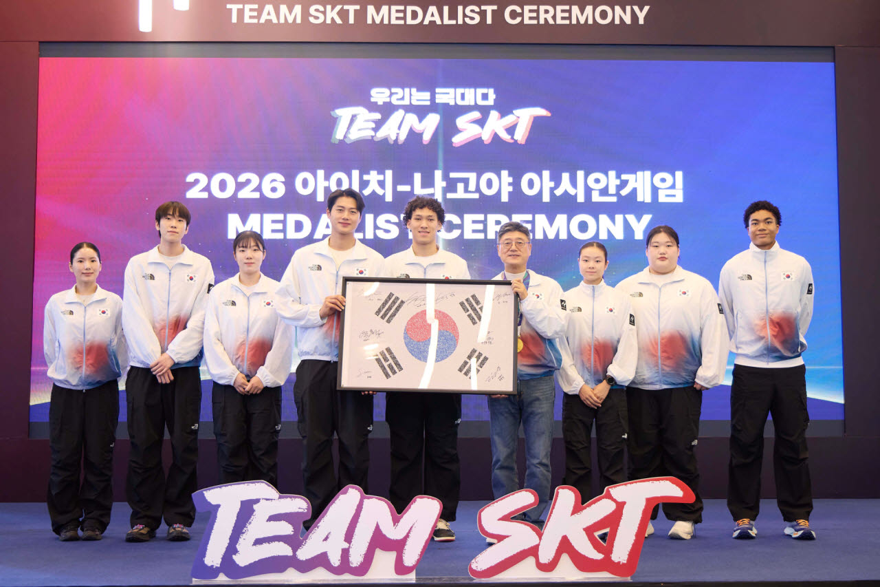 7일 서울 SKT타워에서 열린 '메달리스트 세리머니'에서 'Team SKT' 선수들의 사인을 담은 '국민응원 태극기' 액자를 정재헌 SK텔레콤 CEO에게 전달하고 있는 모습. 왼쪽부터 펜싱 송세라, 도경동, 전하영, 오상욱, 농구 에디 다니엘 선수, 정재헌 CEO, 근대5종 신수민, 역도 박혜정, 육상 나마디 조엘진 선수. 사진=SK텔레콤