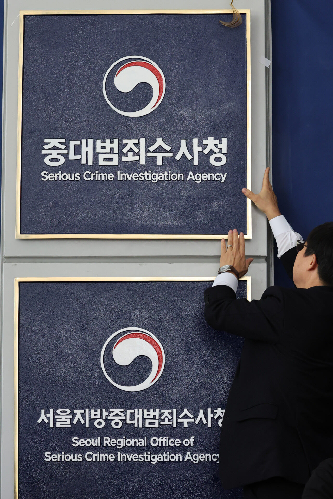 2일 오전 서울 중구 중대범죄수사청에서 개청식이 끝난 뒤 한 관계자가 나사 빠진 현판을 살펴보고 있다. (사진=공동취재단)
