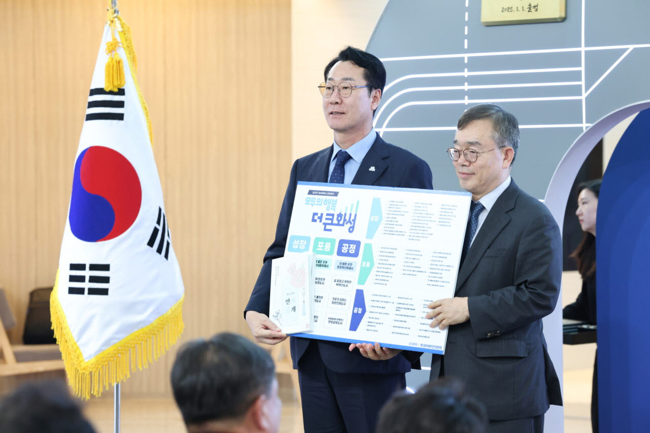 정명근 화성특례시장이 7월 열린 미래비전위원회 성과보고 및 해단식에서 화성특례시의 시정 가치가 적힌 비전보드를 들고 있다.(사진=화성시)