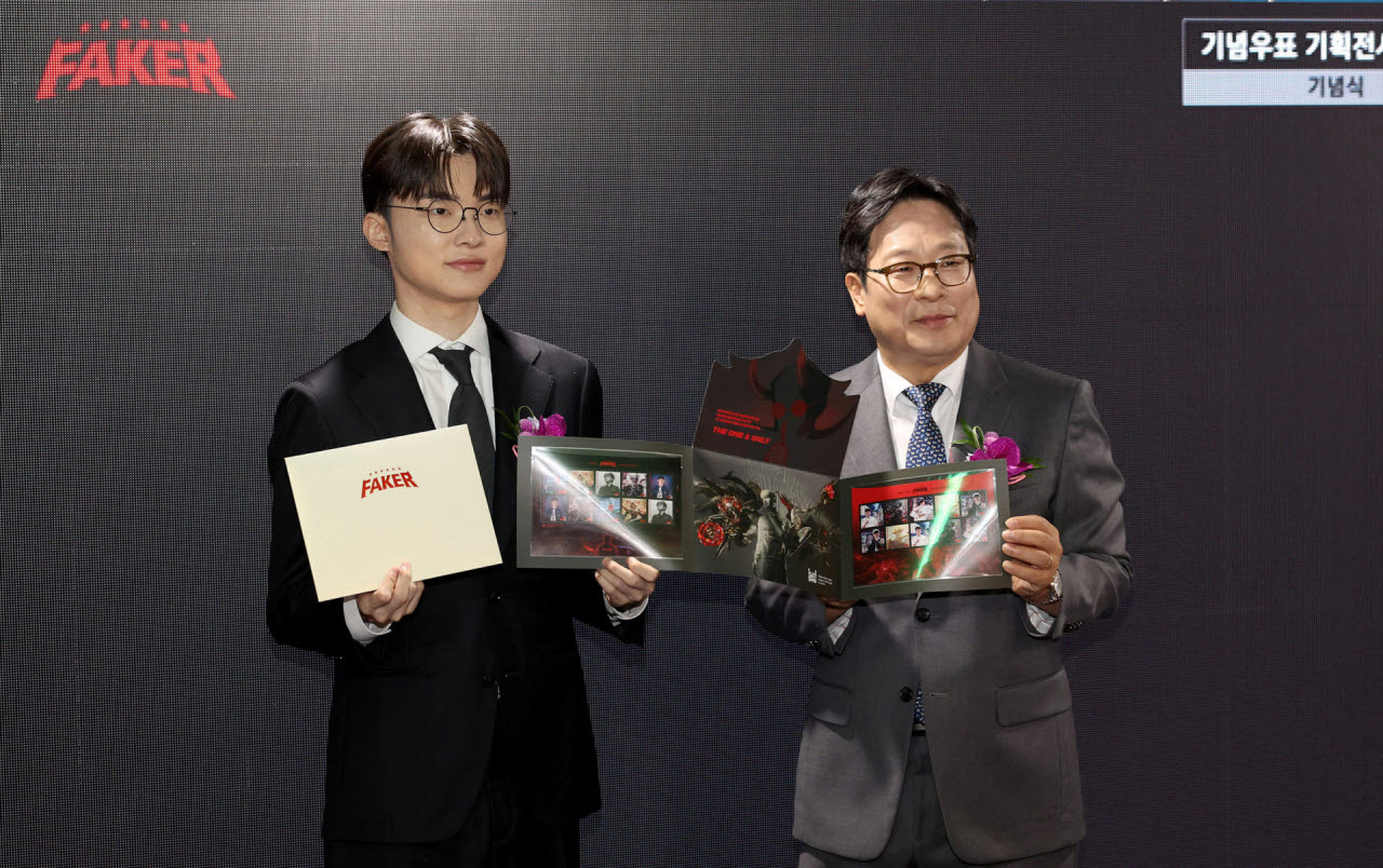 우정사업본부는 10일 서울중앙우체국 우표박물관에 ‘페이커 기획전시관’을 개관했다. 박인환 우정사업본부장(상단 사진 좌측)이 이날 개관식에 참석한 페이커 이상혁 선수에게 기념우표를 전달하고 있다. 사진=우정사업본부