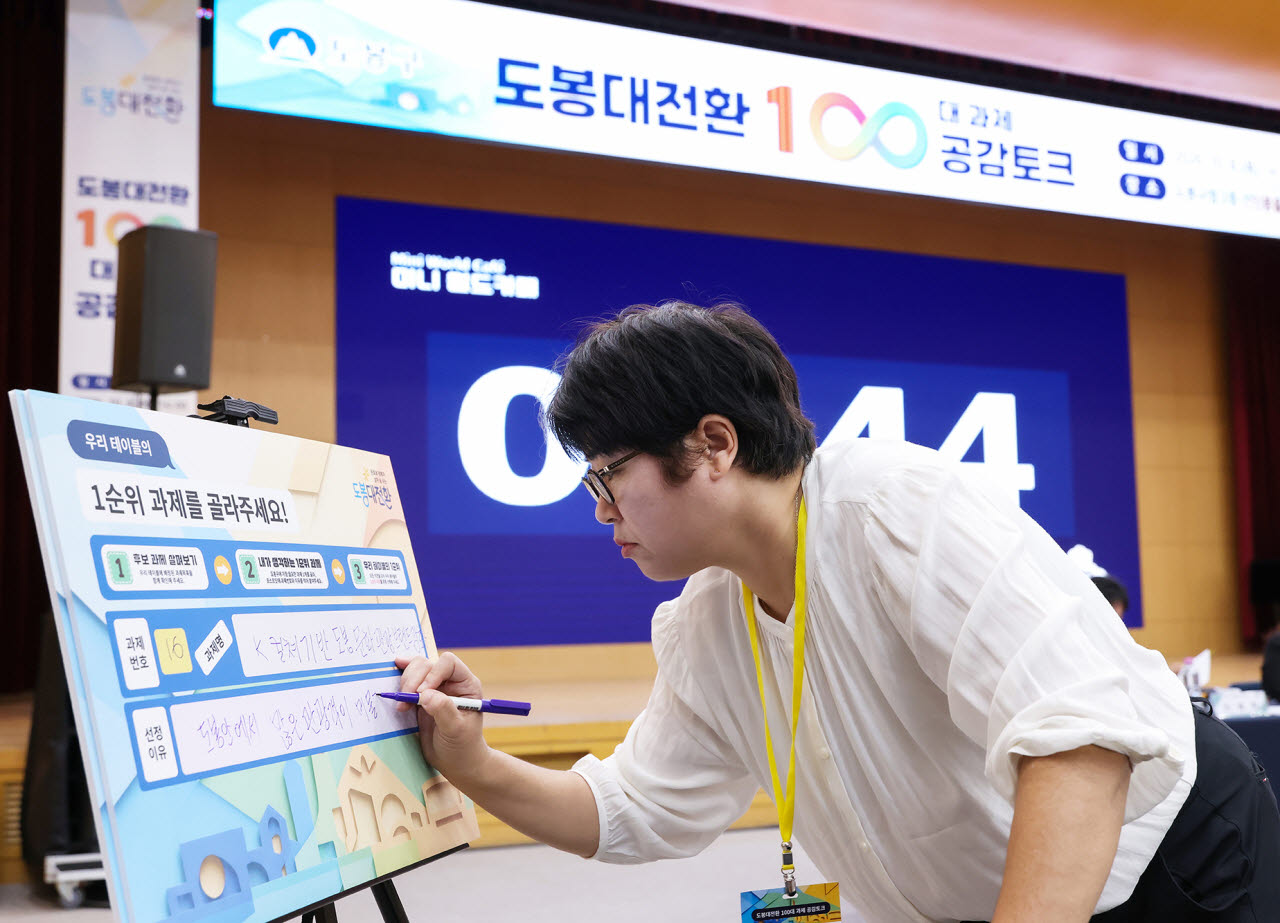 도봉대전환 구민 제안 100대 과제 공감토크 행사 참석자가 모둠에서 토의로 선정한 1순위 과제를 적고 있다.(사진=도봉구)
