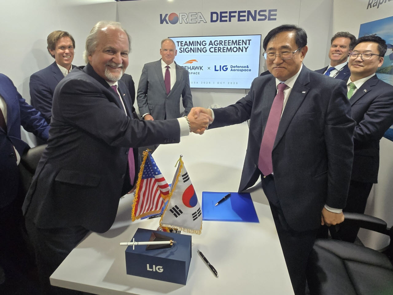 백형식 LIG D&A 해외사업부부문장(앞줄 오른쪽)과 브래드 슈나이더 파이어호크 CFO(앞줄 왼쪽)가 악수하고 있다. (사진=LIG D&A)
