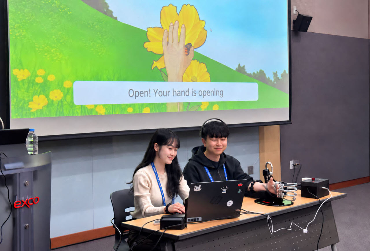 15일 오후 2시 대구 엑스코에서 열린 제14차 세계신경재활총회(WCNR 2026)에서 다이나믹솔루션 관계자가 재활 로봇손 ‘다이나믹 엑스핸드(Dynamic X-hand)’를 시연하고 있다. (사진=다이나믹솔루션)