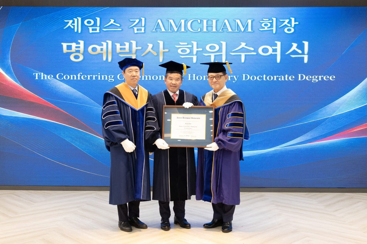 제임스 김 회장 겸 대표이사(사진 가운데)가 15일 명예박사 학위수여식이 진행된 한국항공대 비전홀에서 안준선 대학원장(왼쪽)과 허희영 총장으로부터 학위기를 전달받고 있다. (사진 = 암참)