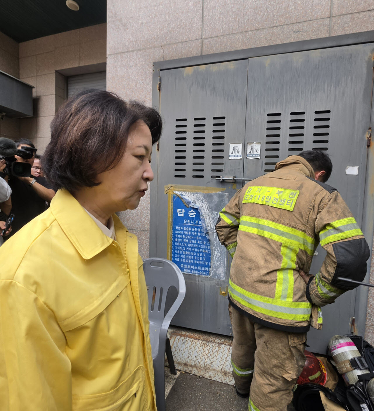추미애 경기도지사가 16일 경기 부천시 한 금속 도장공장 화재 현장을 찾아 동료 부상으로 슬퍼하는 소방대원의 뒷모습을 바라보고 있다. (사진=연합뉴스)