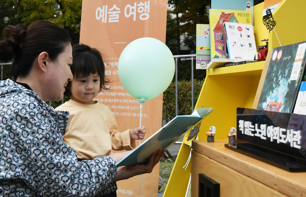 하계동 경춘선숲길에서 개최한 ‘2026 노원 야외도서관 낭만보장’에서 시민과 어린이가 독서를 하고 있다. (사진=노원구)
