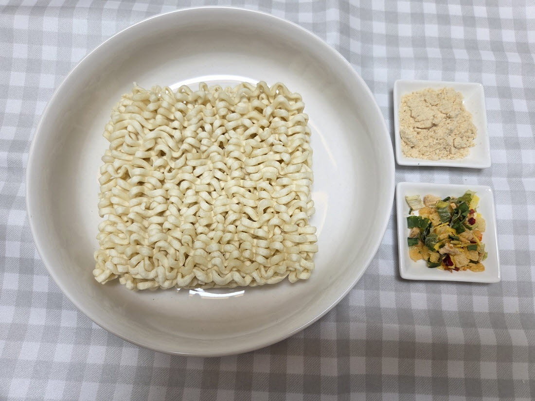오뚜기 ‘동대문식 닭한마리 칼국수’의 면과 분말스프, 건더기스프. 일반 라면보다 폭이 넓은 면이 특징이다. (사진=한전진 기자)