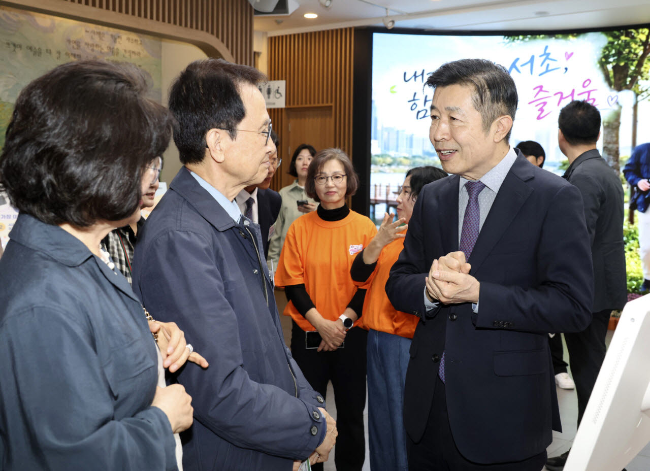 전성수(오른쪽) 서초구청장이 15일(목) 서초구청 1층 로비에서 열린 ‘시니어 숏폼 영상전시회’에서 우수작 선정자들과 대화를 하고 있다. (사진=서초구)