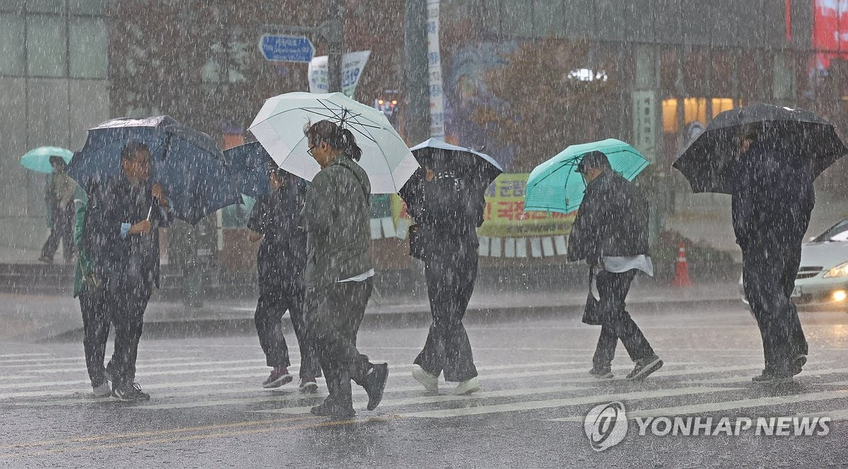 18일 서울 광화문역 인근에서 시민들이 우산을 쓰고 길을 건너고 있다. (사진=연합뉴스)