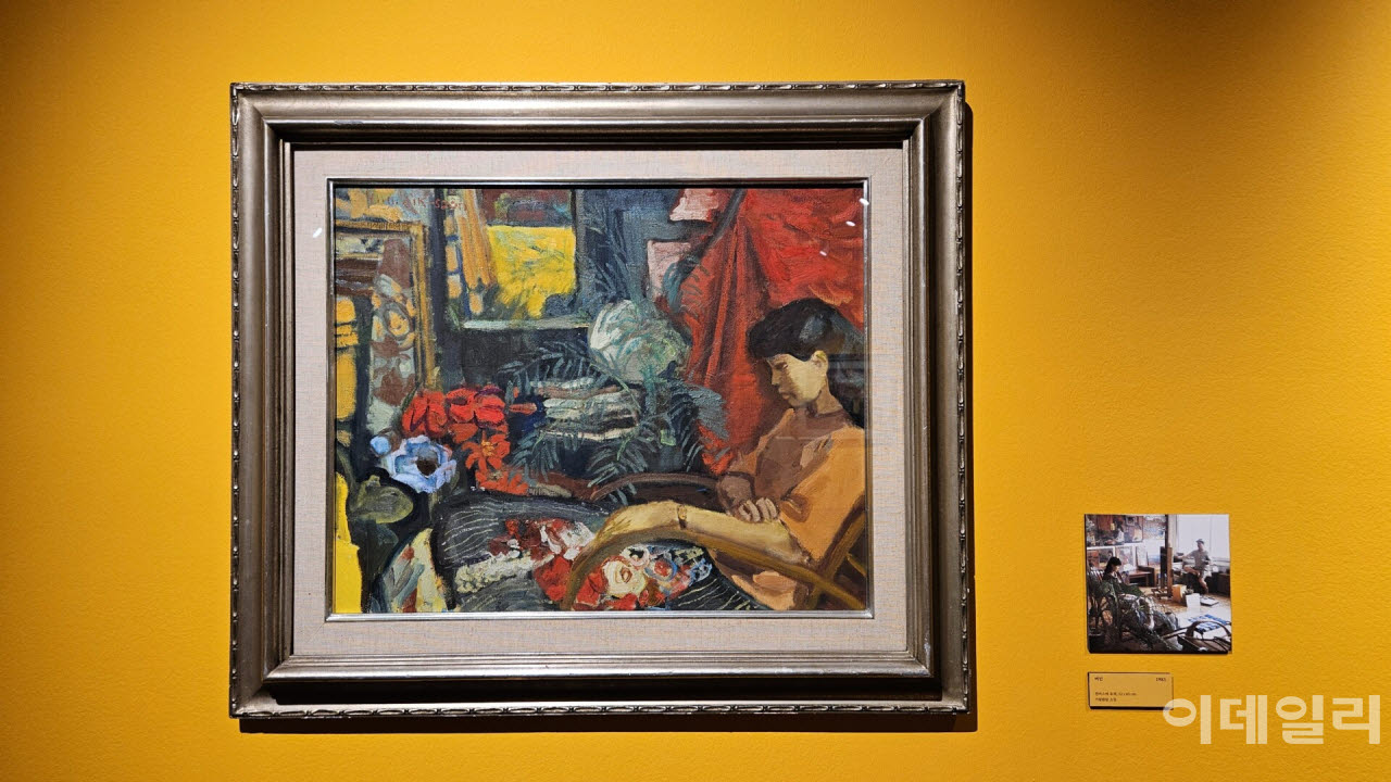 임직순의 ‘여인’(1985, 53×65㎝) 옆으로 모델을 앉혀두고 작업하는 화백을 포착한 사진이 붙었다. 그림은 사진 속 화백의 위치에서 바라보이는 모델의 모습과 일치한다(사진=오현주 문화전문기자).