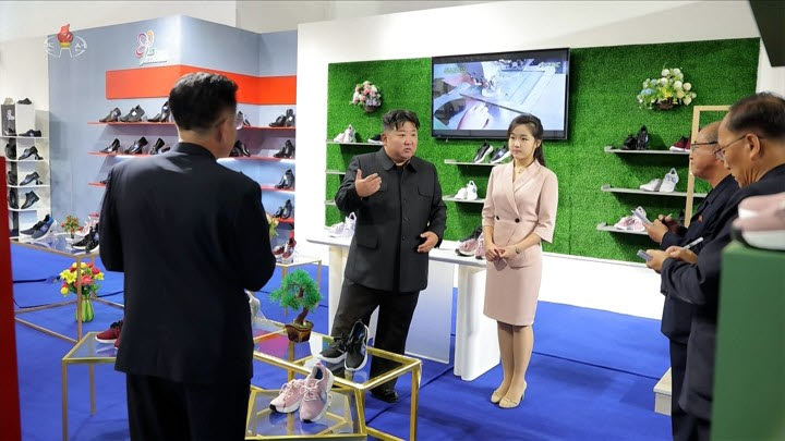 김정은 북한 국무위원장이 지난 19일 '전국피복, 신발전시회-2026'을 찾아 신발 전시대에서 딸 주애가 지켜보는 가운데 간부들과 이야기하고 있다 (사진=연합뉴스)