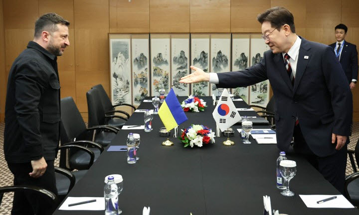 이재명 대통령이 지난 7월 8일(현지시간) 튀르키예 앙카라 한 호텔에서 정상회담에 앞서 볼로디미르 젤렌스키 우크라이나 대통령에게 자리를 안내하고 있다. [연합뉴스 제공]