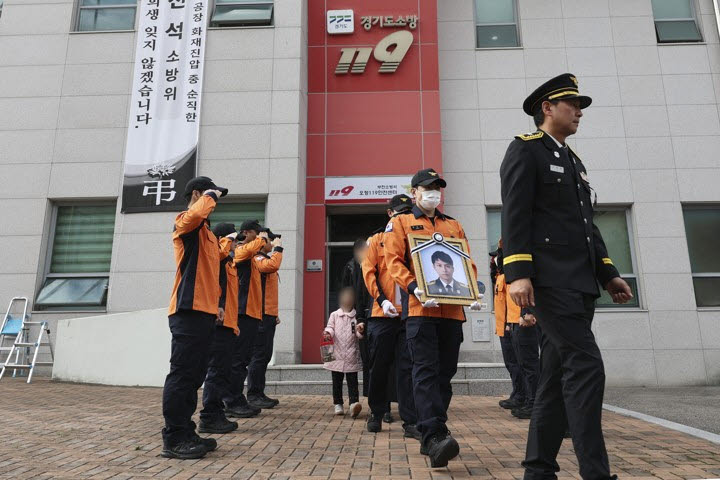 19일 고(故) 김진석 소방위 영결식이 끝난 뒤 동료 소방관들이 영정과 위패를 들고 고인의 생전 근무지인 경기도 부천소방서 오정119안전센터를 돌아본 뒤 건물을 나서고 있다.(사진=연합뉴스)