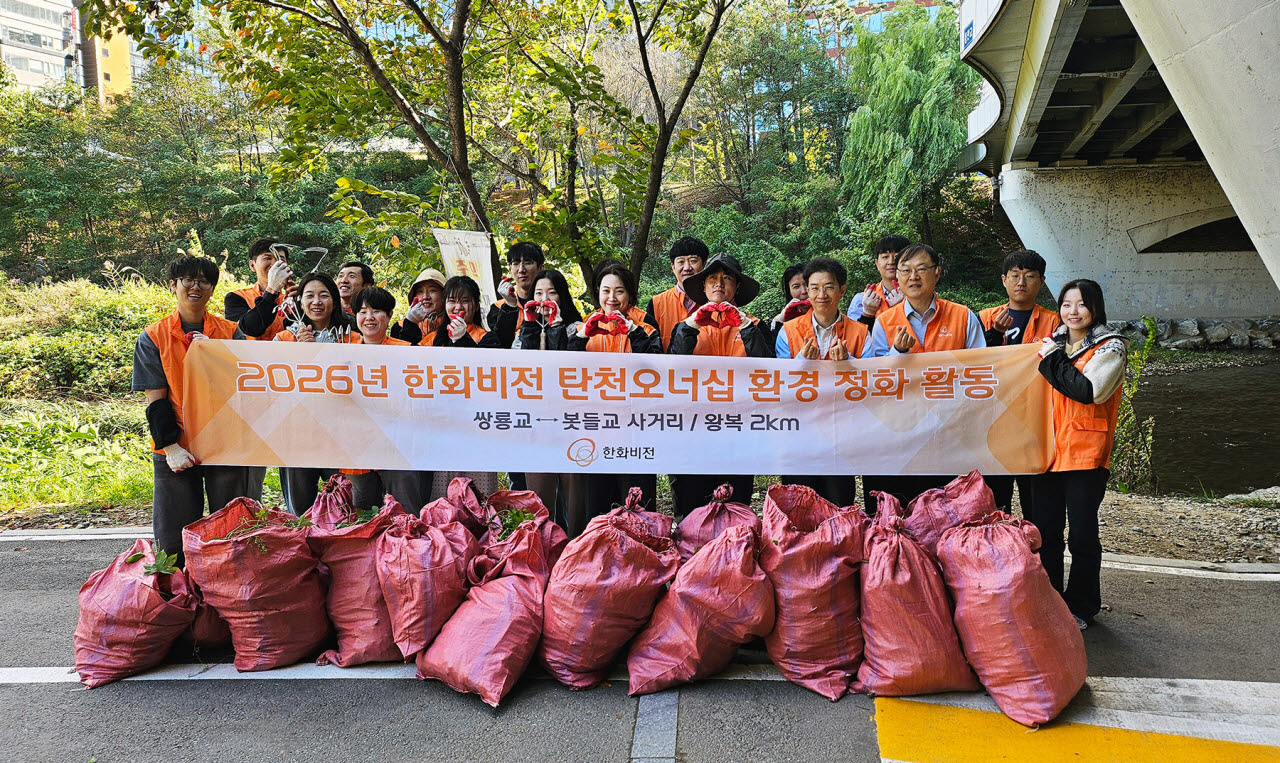 한화비전 임직원들이 지난 21일 성남시 분당구 운중천 일대에서 생물다양성 보전을 위한 ‘유해식물 제거’ 봉사활동을 진행하고 기념 촬영을 하고 있다. (사진=한화비전)