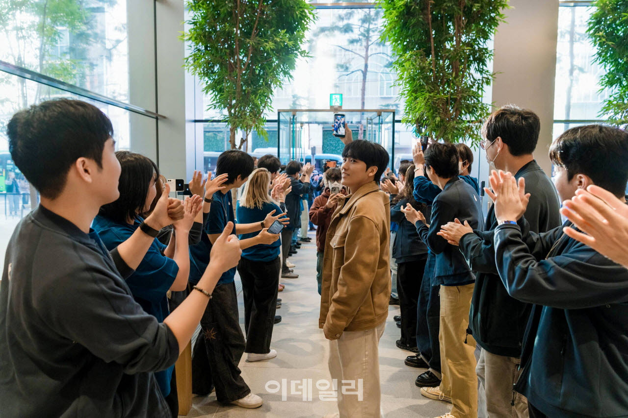 애플의 신제품 ‘아이폰 듀오’ 정식 판매가 시작된 23일 오전 서울 중구 애플 명동에서 첫 번째 구매 고객이 제품 구매를 기념하고 있다. (사진=애플)
