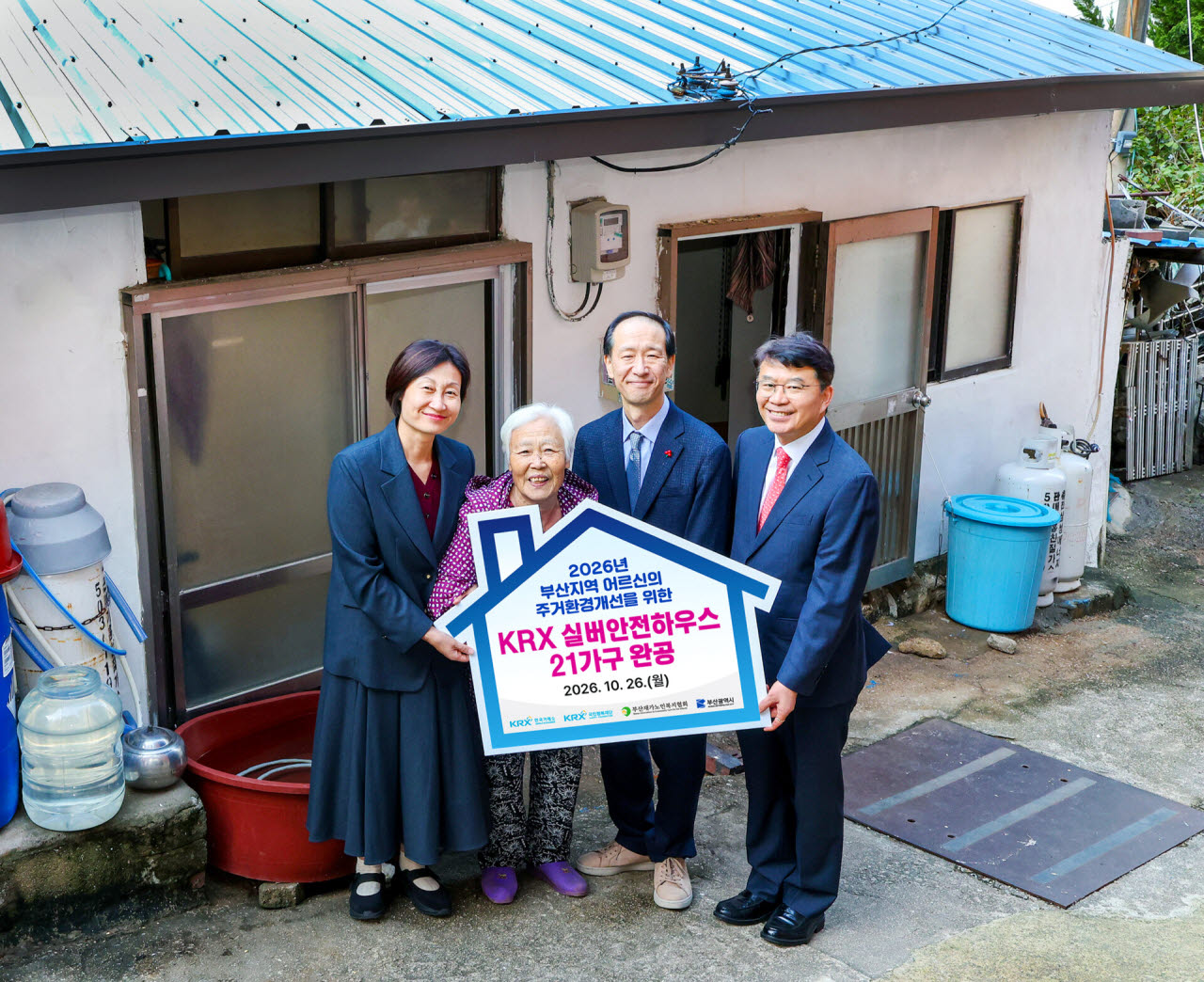 26일 KRX국민행복재단 정상호 사무국장(오른쪽 첫 번째), 부산시청 황순길 사회복지국장(오른쪽에서 두 번째), 부산재가노인복지협회 서보경 회장(왼쪽 첫번째)이 취약계층 어르신들을 위한 집수리 완공 기념촬영을 하고 있다.(사진=한국거래소)