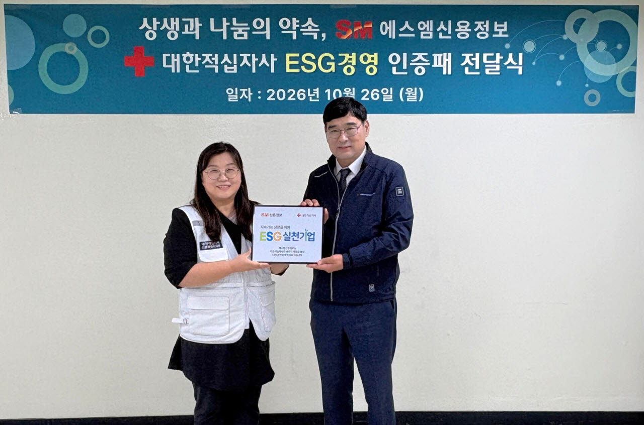 공문용 SM신용정보 대표(오른쪽)가 지난 26일 서울 영등포구 본사에서 열린 대한적십자사 ‘ESG 실천기업’ 인증패 전달식에서 김인숙 나눔기획팀장으로부터 명패를 받은 뒤 기념촬영을 하고 있다. (사진=SM그룹)