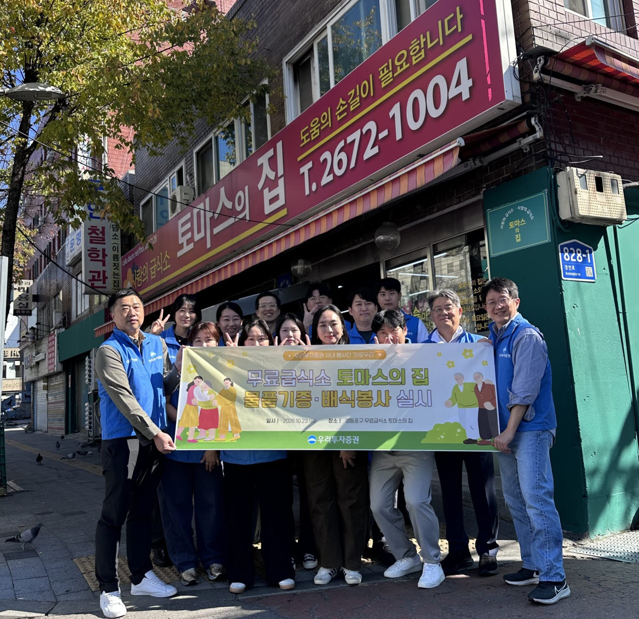 우리투자증권 사내봉사단 '이로우리' 직원들이 지난 23일 서울 영등포구 소재 무료급식소 '토마스의 집'에서 봉사활동을 마친 뒤 기념사진을 촬영하고 있다. (사진=우리투자증권)
