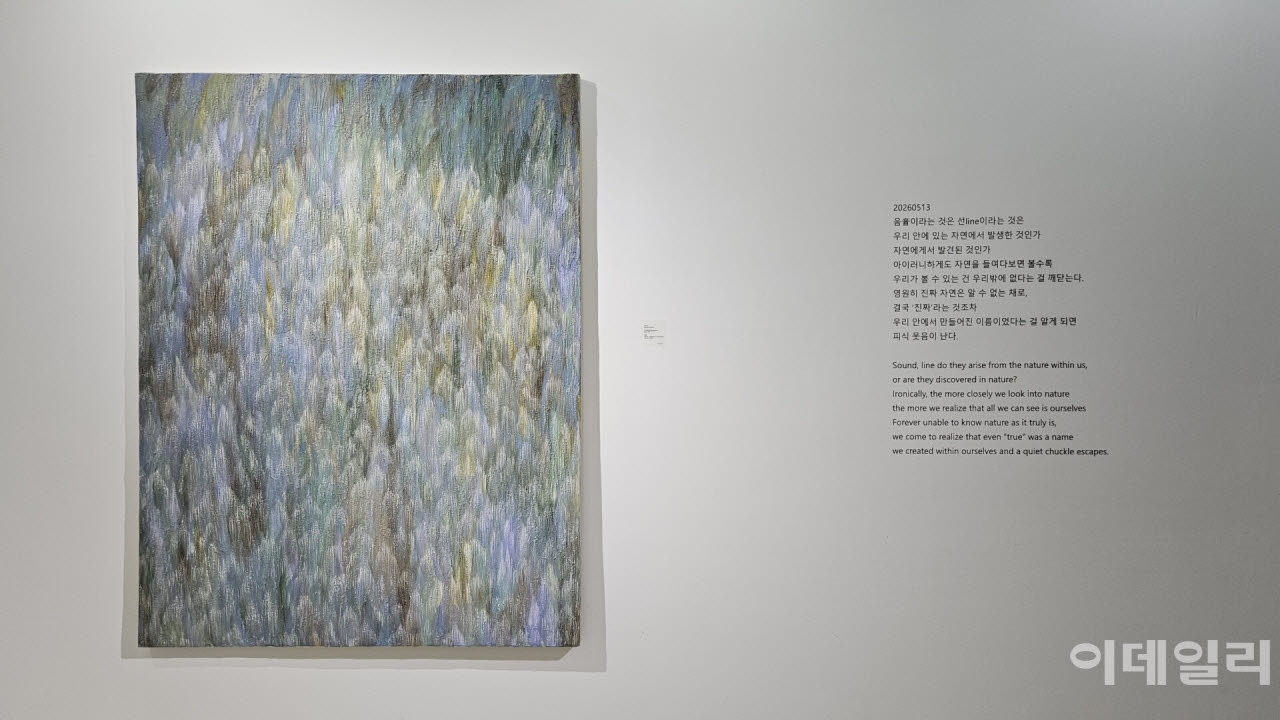 우병윤의 선화랑 개인전 ‘중첩: 들떠 있는 풍경’ 전경. 작품 ‘중첩 26-01-299’(2026, 145.5×112.0㎝)와 함께 작업 중에 떠올렸을 작가의 단상을 옮겨놨다. “아이러니하게도 자연을 들여다보면 볼수록 우리가 볼 수 있는 건 우리밖에 없다는 걸 깨닫는다”고 썼다(사진=오현주 문화전문기자).