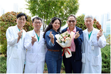 미국인 자선사업가 마르코 씨와 딸 킴벌리 씨가 귀국을 앞두고 건강한 모습으로 21일(수) 서울아산병원 신관 옥외정원에서 간이식·간담도외과 의료진과 기념촬영을 하고 있다. 왼쪽부터 송기원·문덕복 교수, 기증자인 딸 킴벌리 씨, 수혜자 마르코 씨, 이승규 석좌교수.