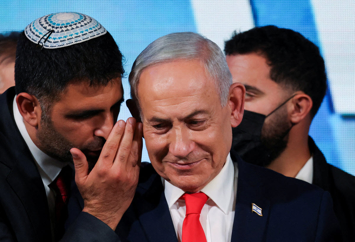 An aide speaks to Israeli Prime Minister and Likud party leader Benjamin Netanyahu as he gives a statement following exit polls for Israel's national election, at Likud's election headquarters in Jerusalem, October 28, 2026. REUTERS/Ammar Awad TPX IMAGES OF THE DAY