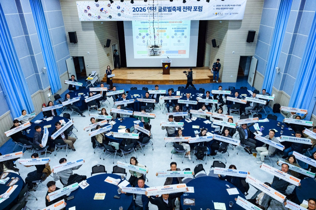 22일 경기 연천군 종합복지관에서 열린 ‘2026 연천 글로벌축제 전략 포럼’ 참석자들이 K-축제의 글로벌 도약과 ‘2029 연천세계구석기엑스포’ 성공 개최를 다짐하는 손 피켓을 들고 기념촬영을 하고 있다.(사진=연천군청)