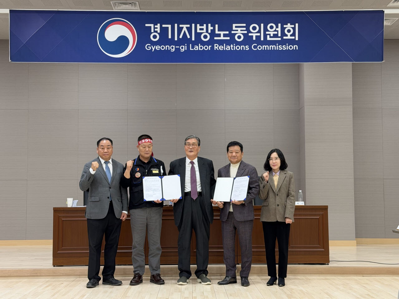 30일 경기지방노동위원회에서 진행된 최종 조정회의에서 경기도 버스 노사 및 지노위 관계자들이 합의안을 들고 기념촬영을 하고 있다.(사진=뉴시스)