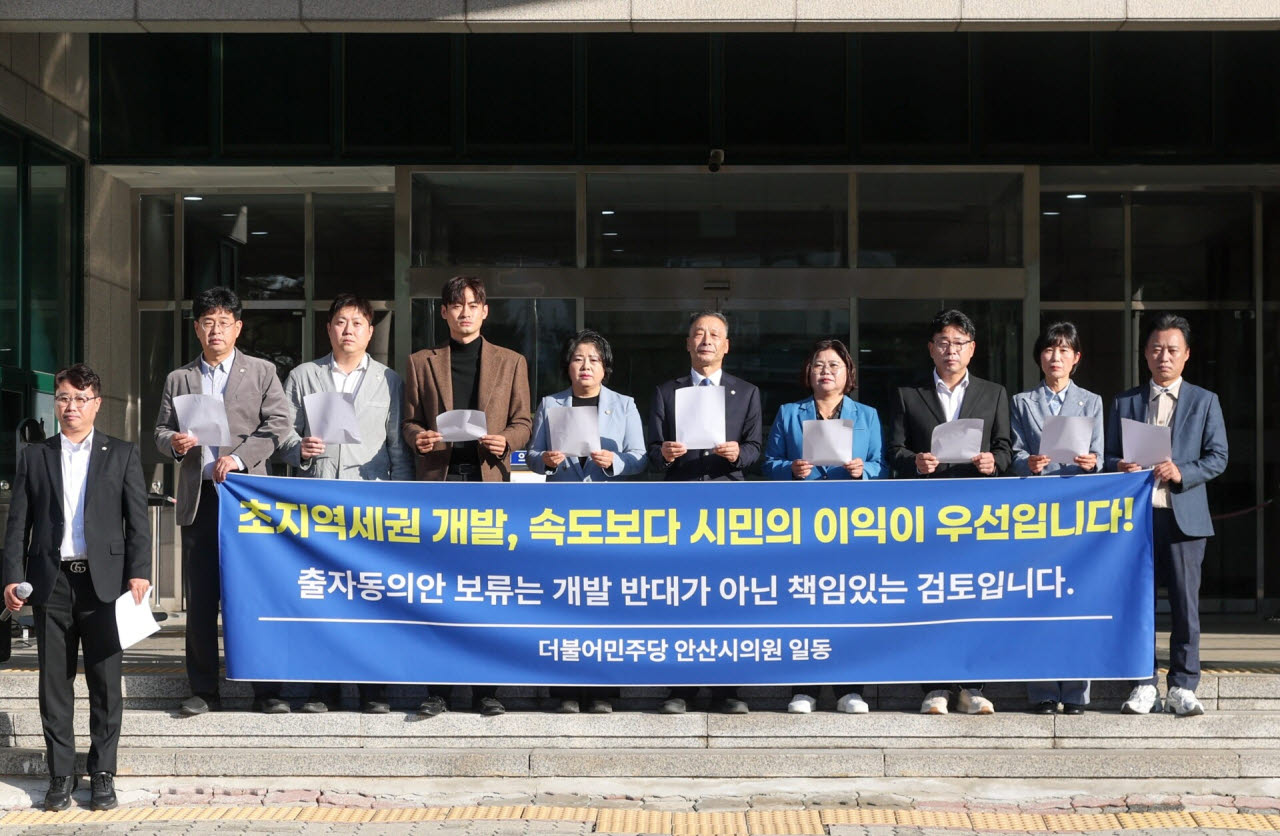 민주당 안산시의원 10명이 30일 시의회 앞에서 국민의힘 의원들의 비판을 반박하는 성명을 발표한 뒤 기념 촬영하고 있다. (사진 = 민주당측 제공)