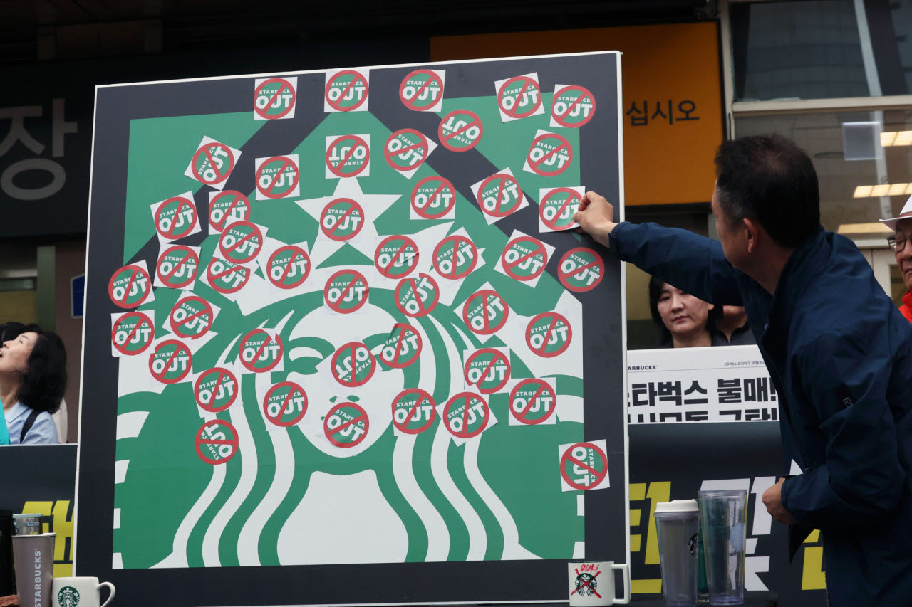 오월을 사랑하는 모임 등 광주 시민단체들이 광주 서구 이마트 광주점 앞에서 스타벅스의 '5·18 탱크데이' 마케팅을 규탄하며 '스타벅스 OUT' 스티커를 붙이고 있다. (사진=뉴스1)