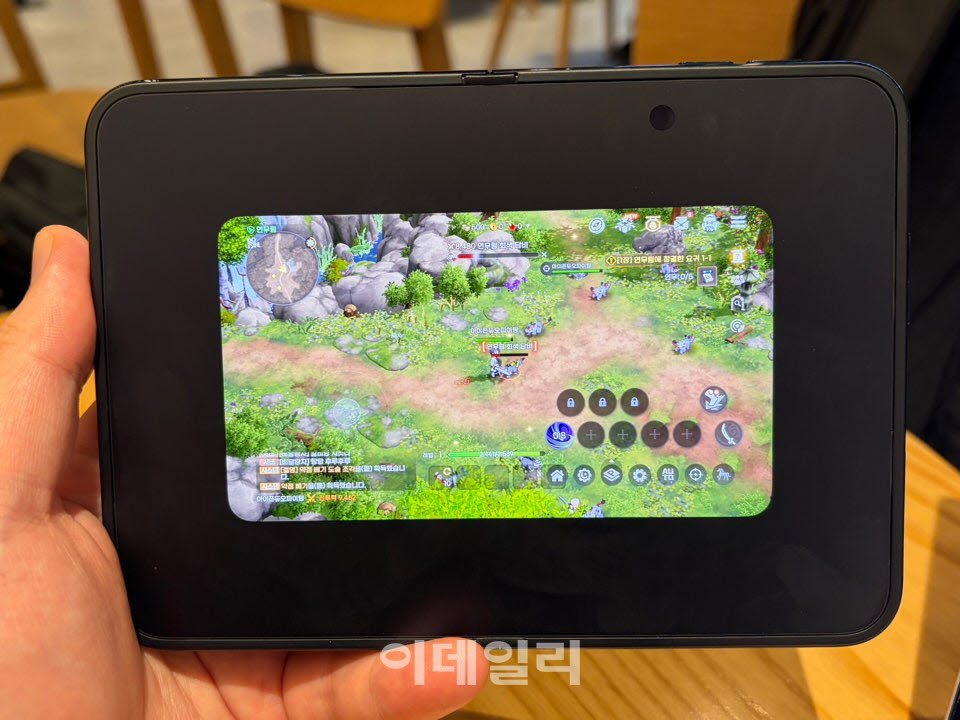 아이폰 듀오를 펼쳐 가로로 든 채 ‘도깨비의 세계’를 실행한 모습. 촬영 당시 앱이 내부 디스플레이를 충분히 활용하지 못하고 작은 화면으로 표시됐다. (사진=신영빈 기자)