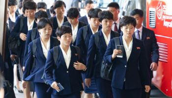 손에 여권쥐고 버스로 향하는 북한 여자축구팀